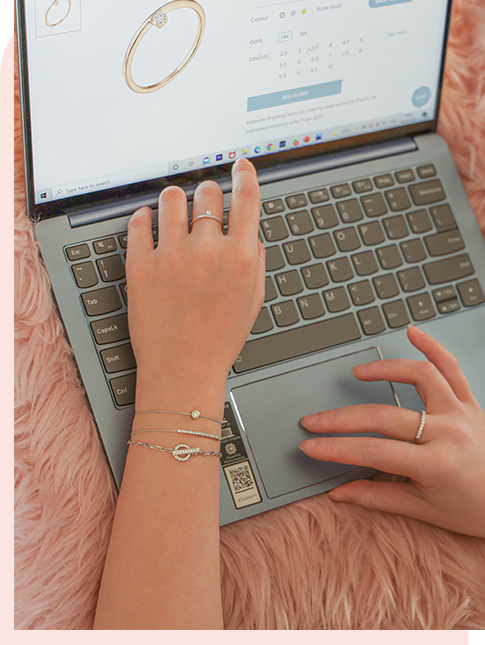 Hands adorned with mori rings and bracelet shopping for jewelry online, showcasing elegant accessories